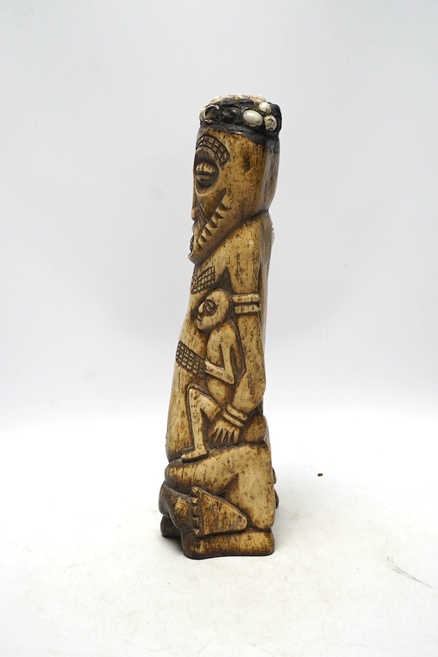 A West African carved animal bone fertility figure, 34cm. Condition - fair
